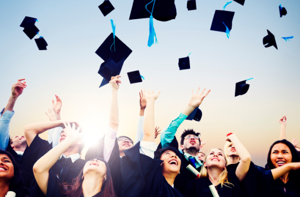 Cheerful students throwing graduation caps in the Air