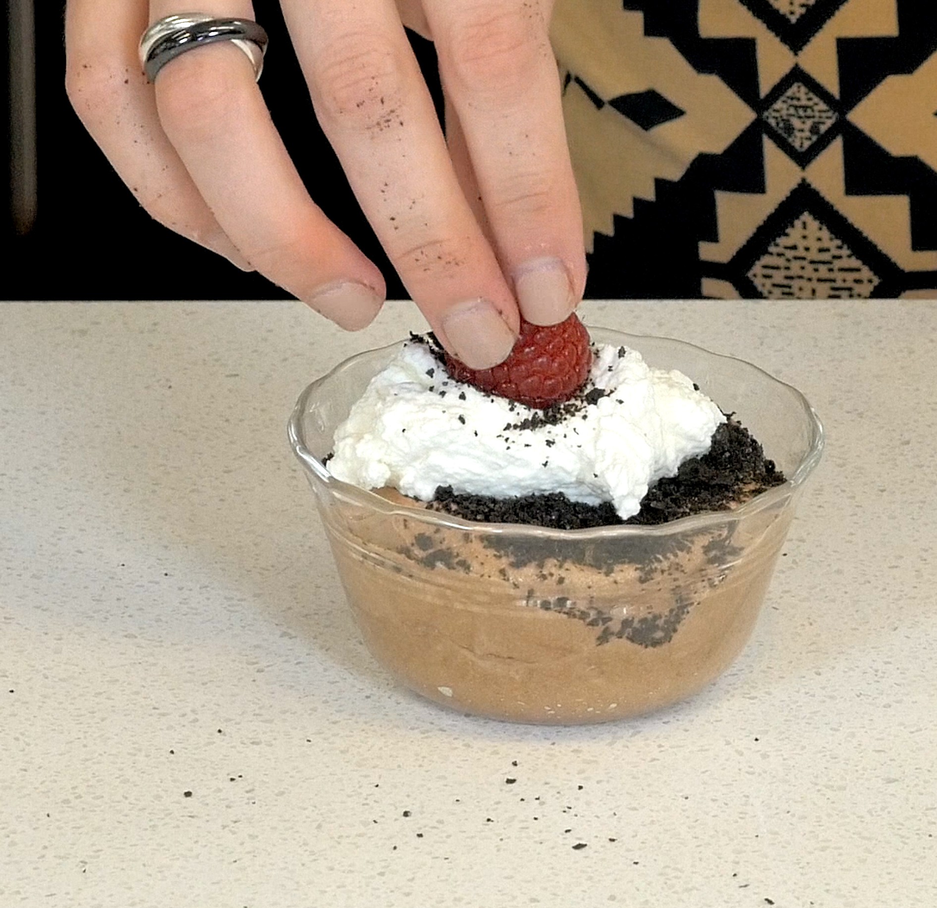 pudding cup with whipped cream and raspberry